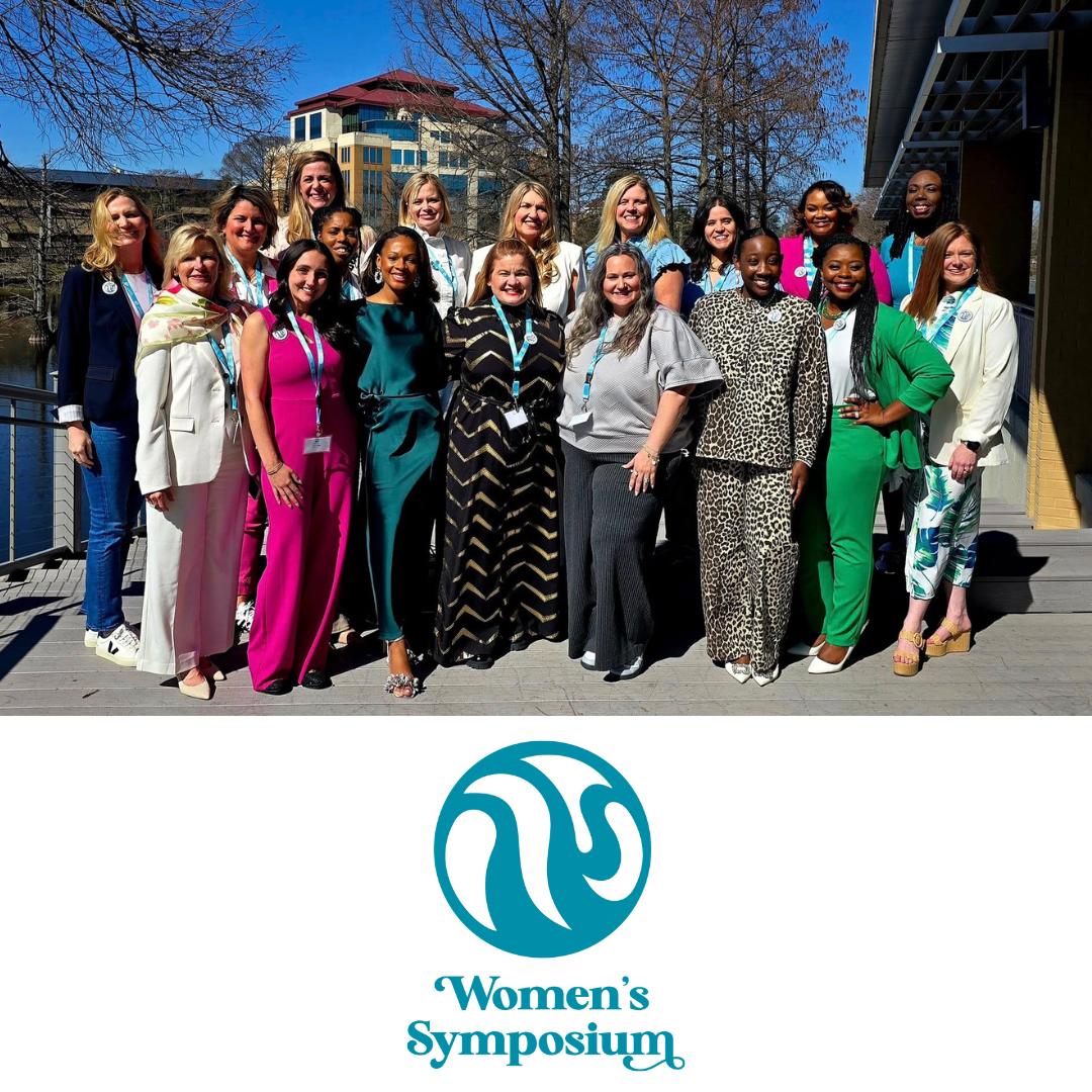 Group of women posing together outdoors on campus at the ULM Women’s Symposium event.