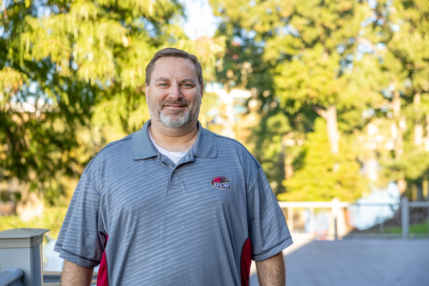 Portrait of Tim Rightsell, ULM Alumni Association Board Member, standing on campus near the bayou.