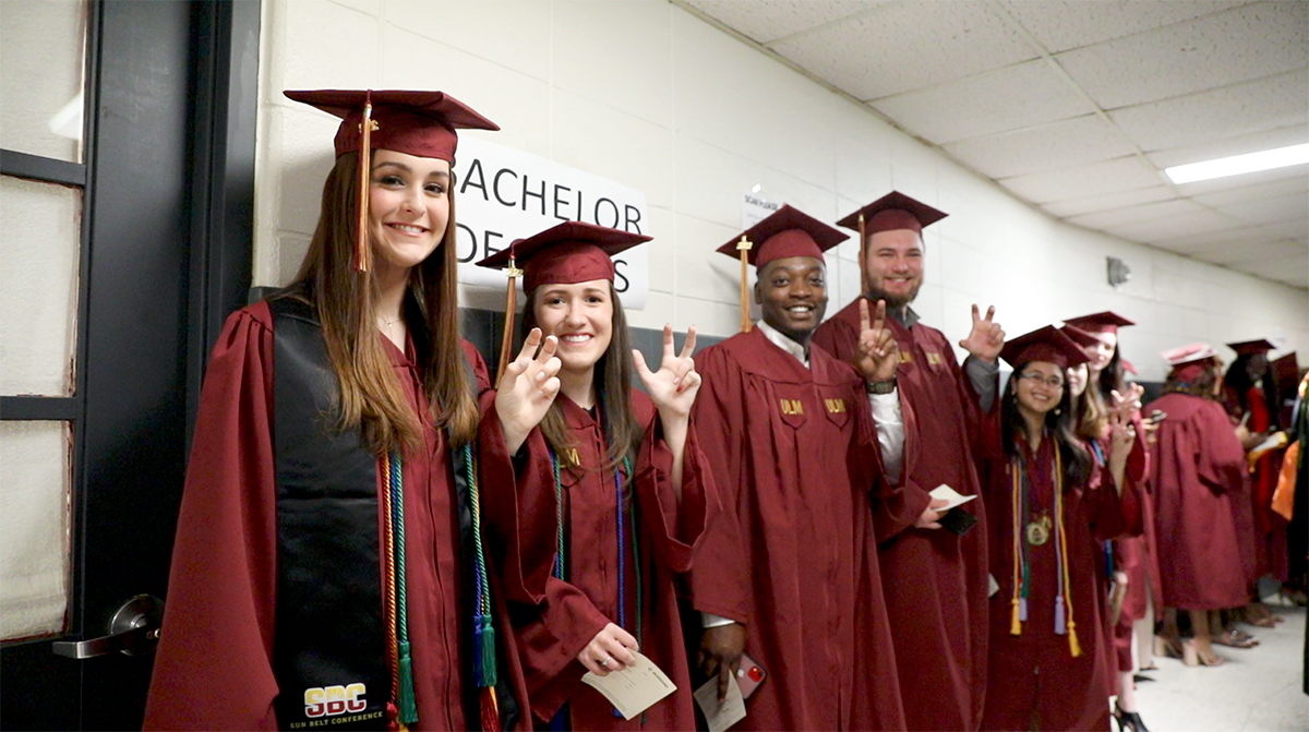 Students dressed in maroon gowns and caps lined up against the wall in Fant Ewing waiting for the processional