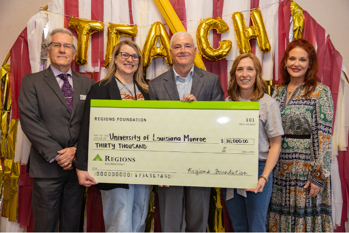 a group of people holding a large ceremonial check from the Regions Foundation