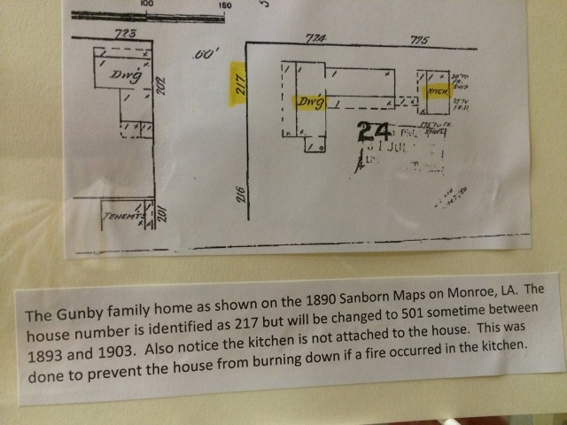 The display includes an 1890 Sanborn Map image of the Gunby home. Text under the image states the house number is identified as 217 but will be changed to 501 sometime between 1893 and 1903. The text also mentions that the kitchen is not attached to the main house, noting this was an effort made to protect the house from burning down.