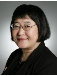 Composer Chen Yi is seated and wearing black clothes.
