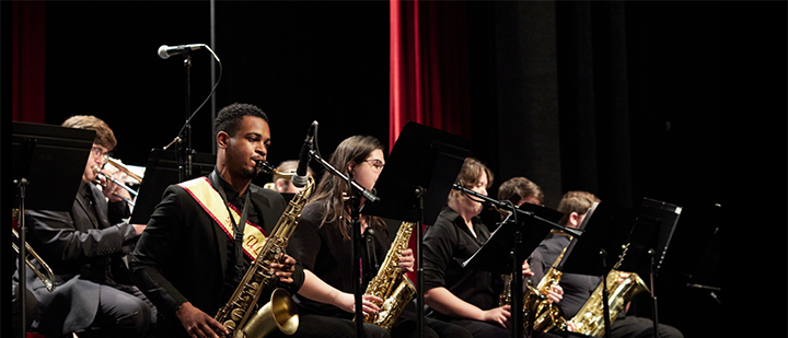 Members of the ULM Jazz Ensemble's saxophone section performing on stage in Brown Auditorium.