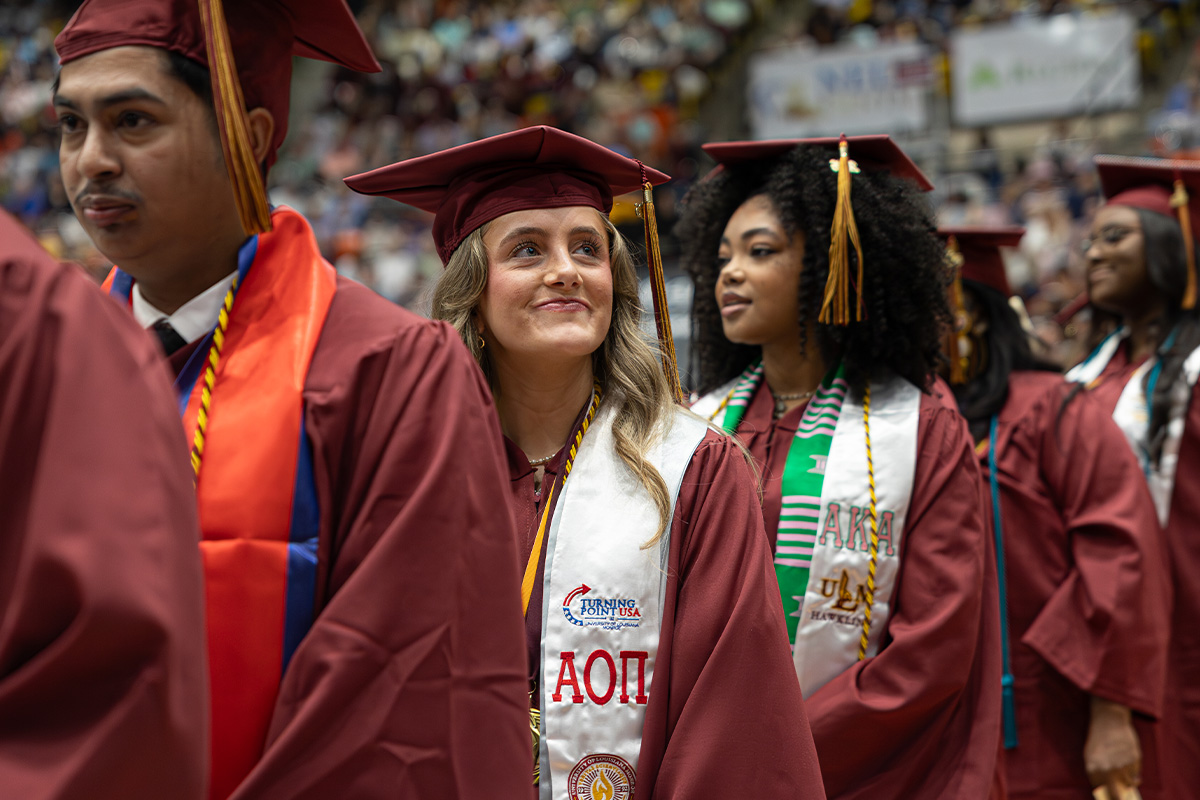 A group of graduates in caps and gowns stand in line at ULM's spring 2026 commencement ceremonies. 