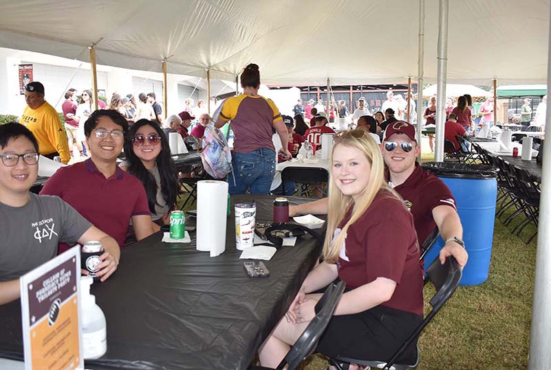Group of College of Pharmacy students under the COP tent at ULM Homecoming tailgate.