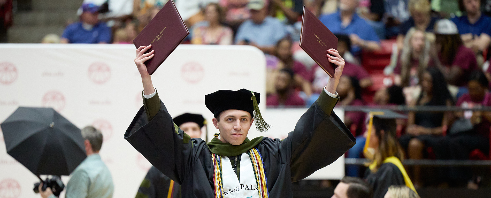 Pharmacy student displaying two diplomas for participating in a dual degree program.