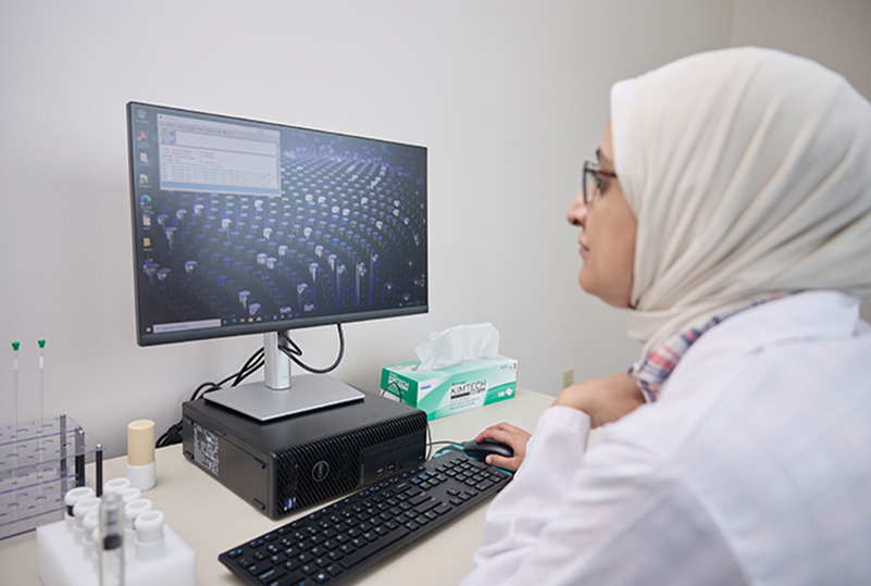Graduate Student working on a software program associated with the NMR machine.