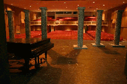 A view looking from the stage of Brown Auditorium into the audience. A grand piano sits on stage.